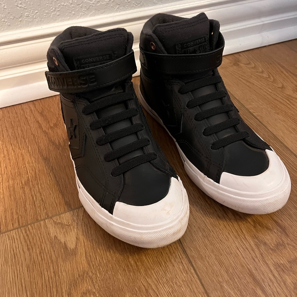 Black and white Converse with strap.
